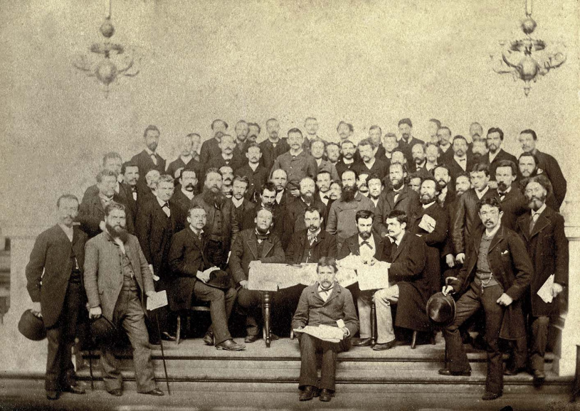 De stichters van de BWP op het partijcongres in Antwerpen op 15 en 16 augustus 1885. Aan het midden van de tafel zit Louis Bertrand, links Edmond van Beveren en Edward Anseele (met bolhoed op schoot). Vlak achter Bertrand staat César de Paepe. (Amsab-ISG, fo002780)